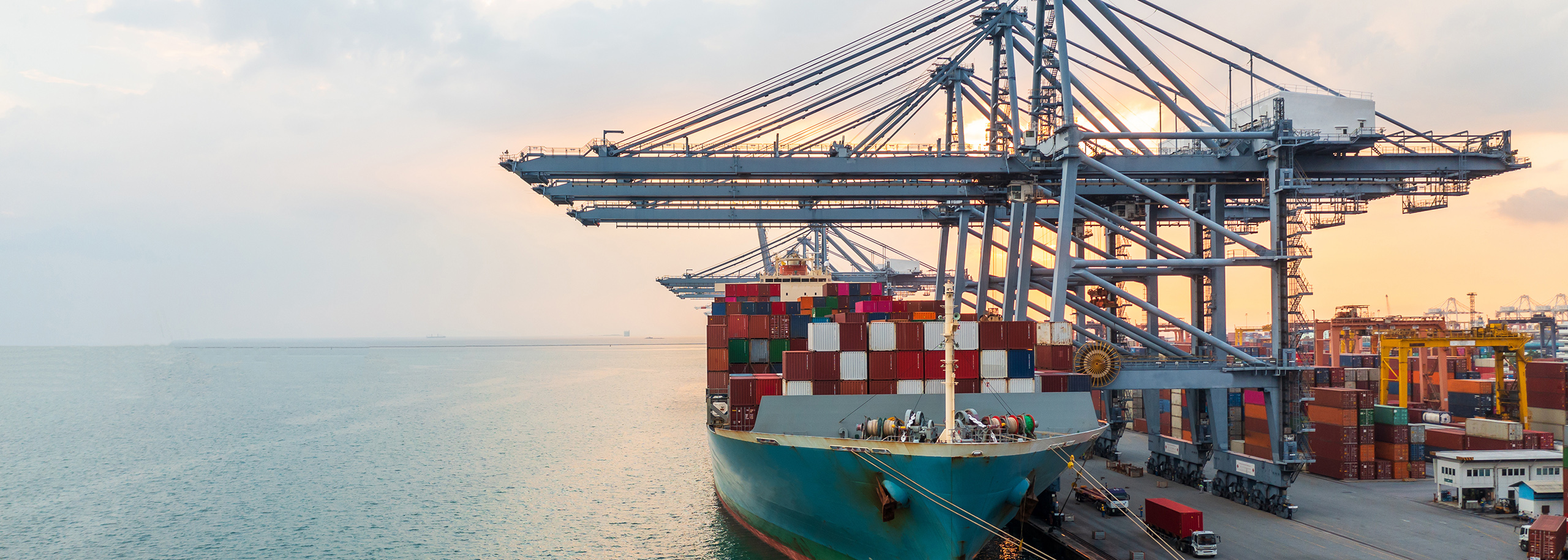 Schwerlast-Kräne im Hafen – Symbolbild für Sonderschrauben im Bereich Hochlast-Kräne Containerhafen mit Schwerlast-Kränen und Containerschiff – Symbolbild für Sonderschrauben und Verbindungslösungen von Stahlberg im Bereich hochbelasteter Kräne