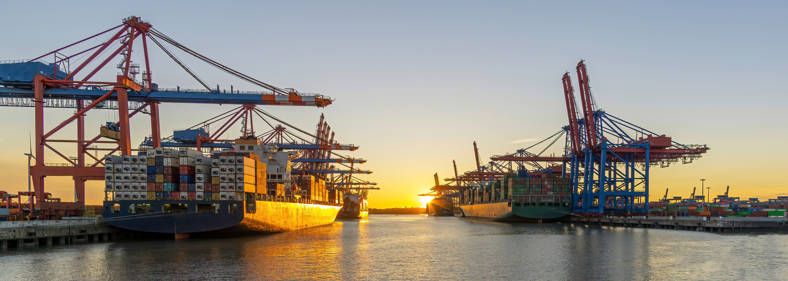 Schwerlast-Kräne im Hafen – Symbolbild für Sondermaschinenbau im Bereich Hochlast-Kräne Mehrere Containerkräne mit Containerschiffen im Hamburger Hafen – Symbolbild für Sonderschrauben und Verbindungslösungen von Stahlberg im Bereich hochbelasteter Kräne
