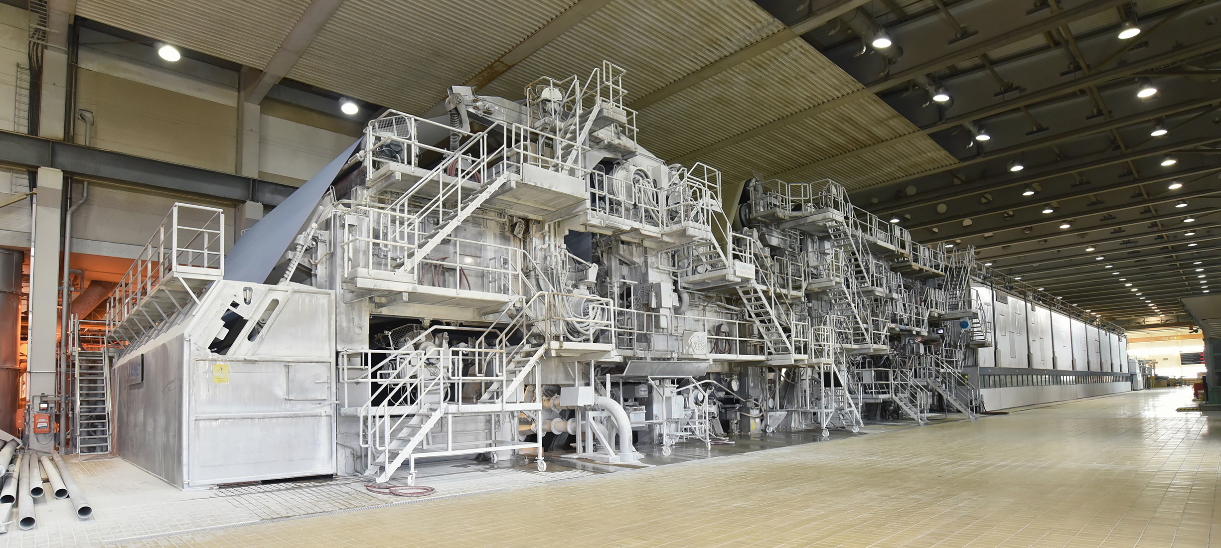 Papiermaschine- Symbolbild für Sondermaschinenbau im Papiermaschinenbau Papiermaschine in einer industriellen Produktionshalle – Symbolbild für Sonderschrauben der Stahlberg GmbH im Bereich Papiermaschinenbau.