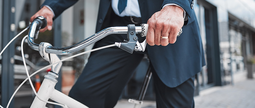 Lastenräder und E-Bikes - Stahlberg fördert emissionsfreie Fortbewegung der Mitarbeiter Bildausschnitt von einem Mann auf einem Fahrrad als Symbolbild für die Förderung von emissionsfreien Fortbewegungsmitteln bei Stahlberg